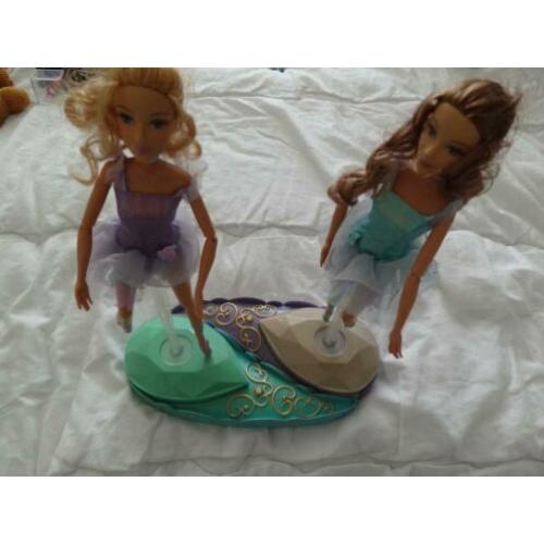 2 barbiepoppen die draaien op staander