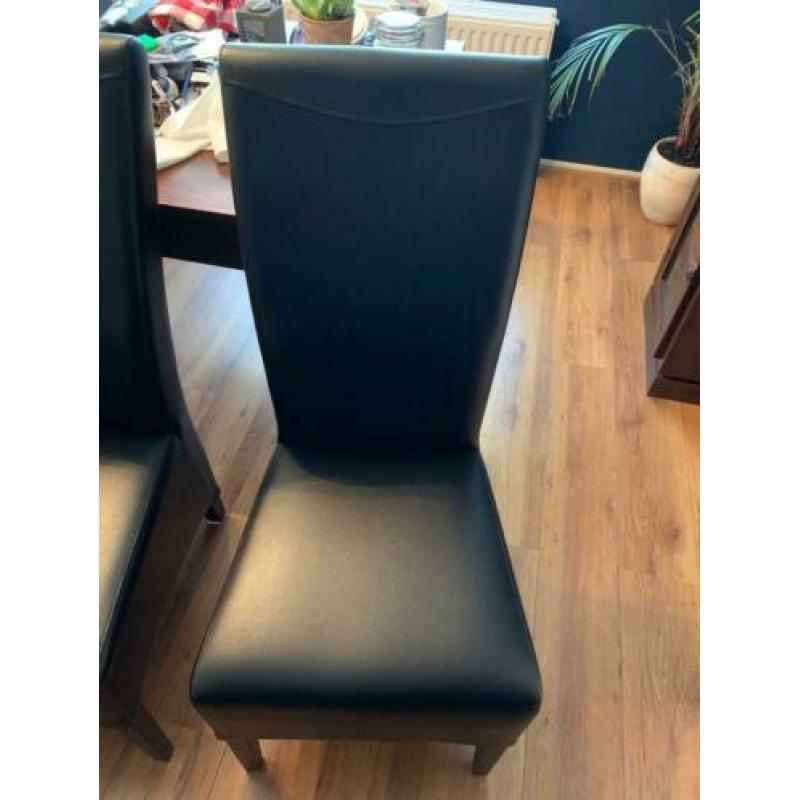 Mooie teak houten eettafel met vier zwart lederen stoelen